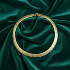 Gold bracelet on a green satin fabric background