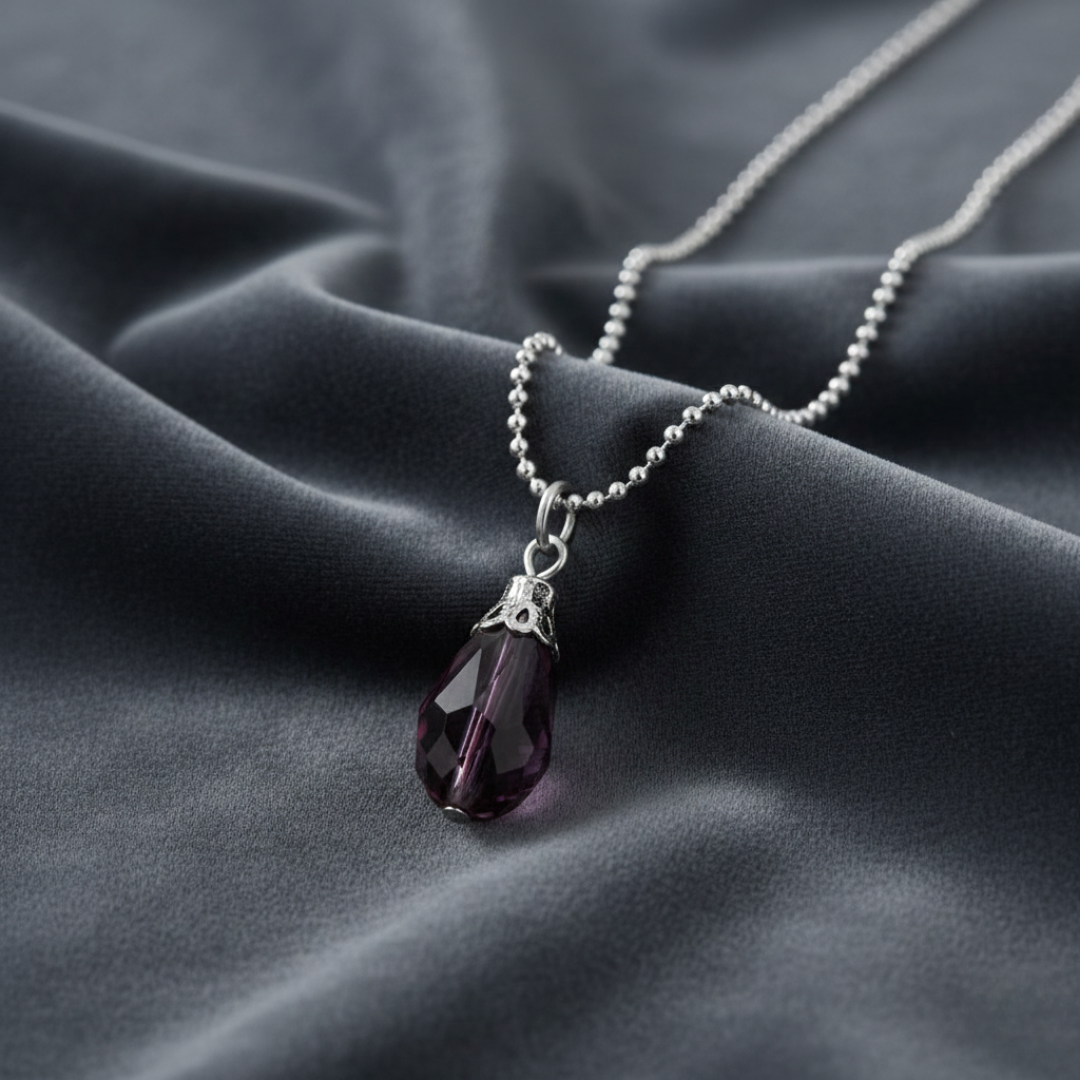 Necklace with a purple crystal pendant on a dark fabric background