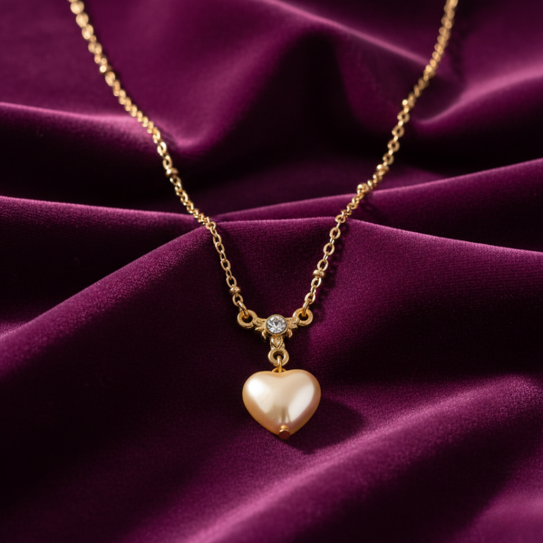 Gold necklace with a heart-shaped pendant on a purple fabric background