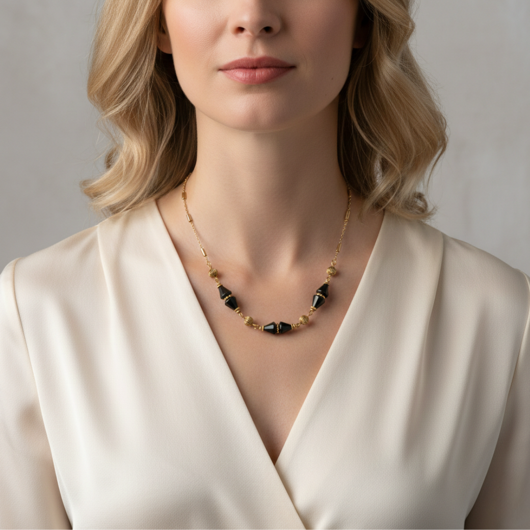 Woman wearing a gold and black beaded necklace against a neutral background