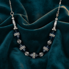 Necklace with blue and silver beads on a dark green fabric background
