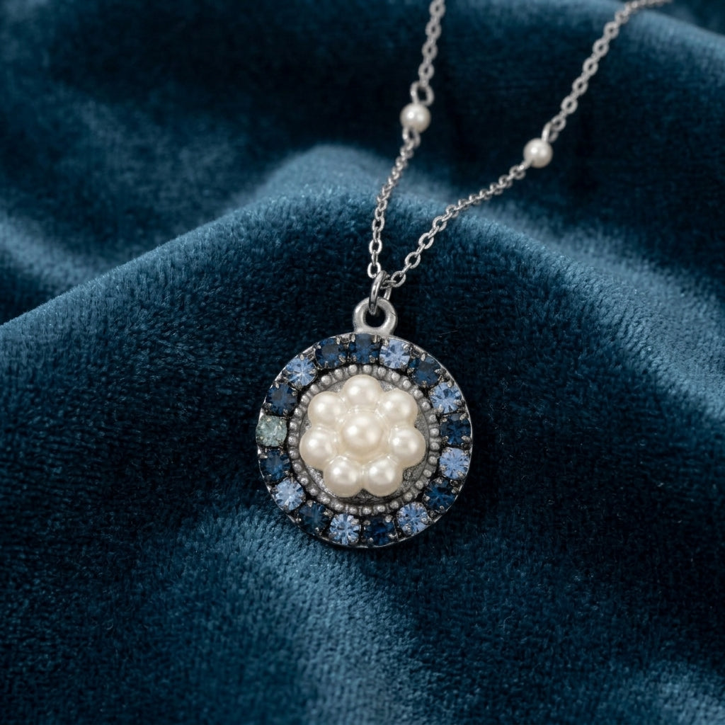 Hanauma Floral Faux Pearl Crystal Pendant Necklace on a blue fabric background