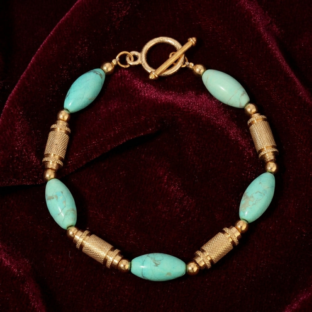 Bracelet with turquoise gemstones and gold accents on a red velvet background