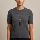 Person wearing a gray sweater with an Oval Blue Stone Etched Whistle Pendant Necklace