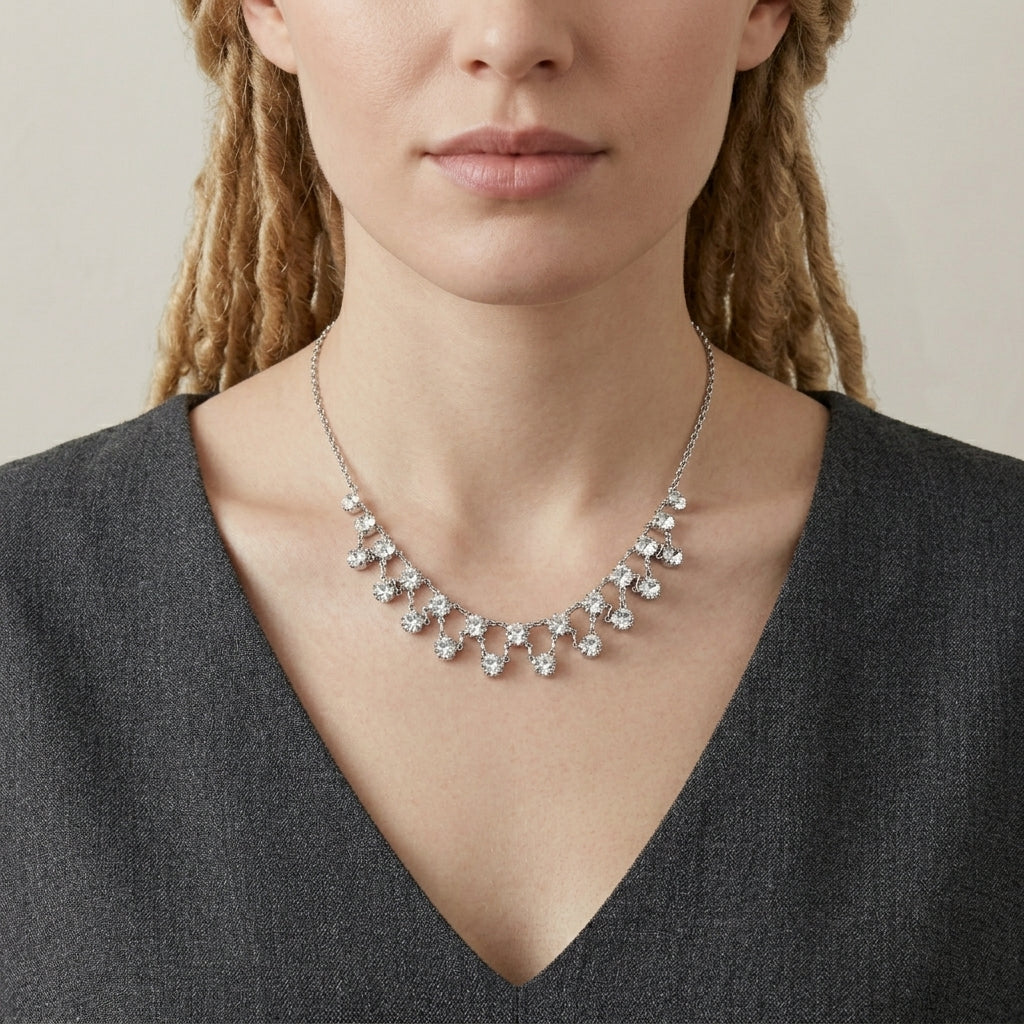 Woman wearing a silver necklace with clear crystals a neutral background
