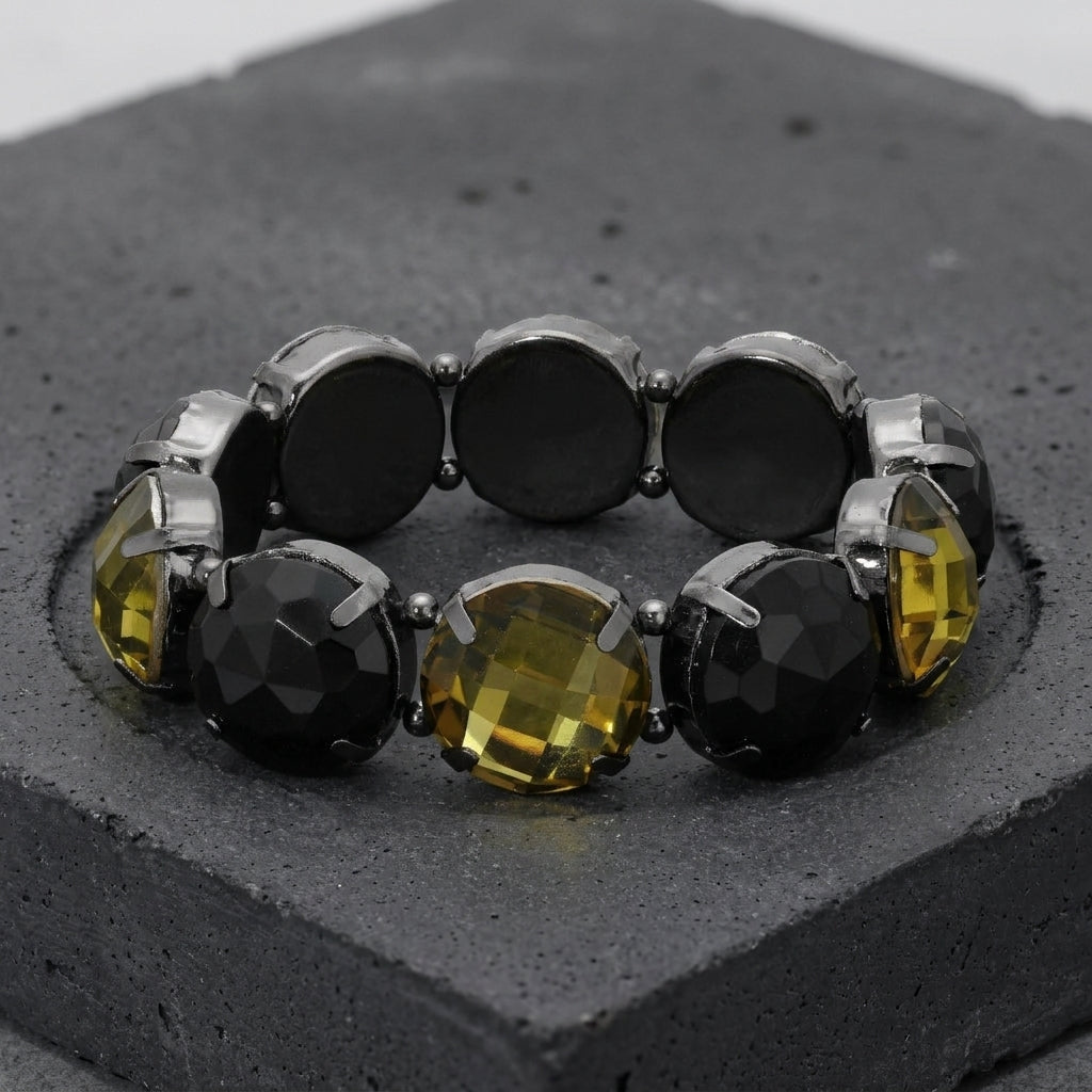 Bracelet with black and yellow gemstones on a textured gray surface