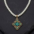 Pearl Strand Multi Crystal Filigree Pendant Necklace on a dark stone background