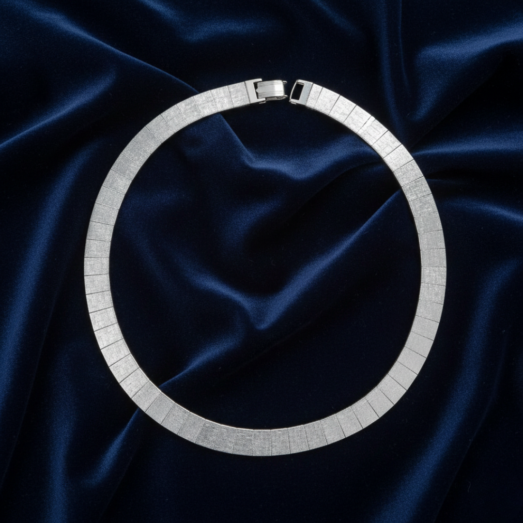 Silver necklace on a dark blue satin fabric