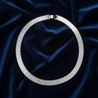 Silver necklace on a dark blue satin fabric