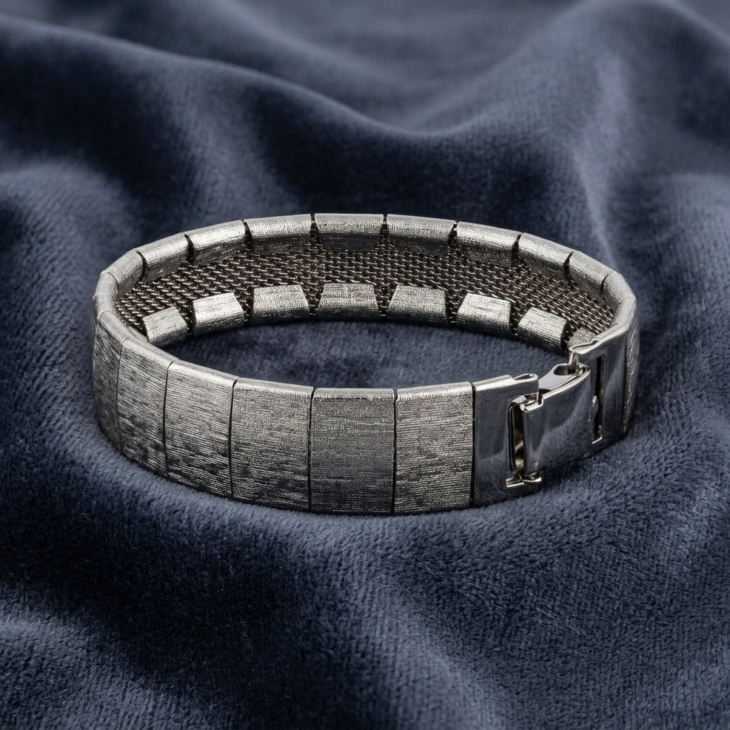Silver bracelet on a textured blue fabric background