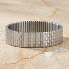 Silver Infinite Stretch Bracelet on a textured beige stone urface