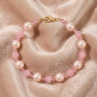 Pink pearl bracelet on a soft pink fabric background