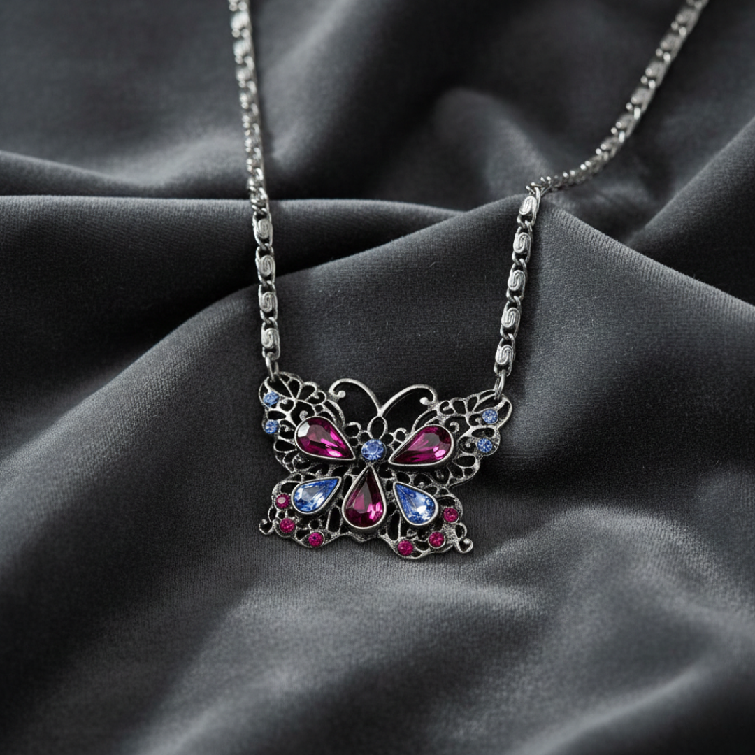 Butterfly-shaped necklace with colorful gemstones on a dark fabric background