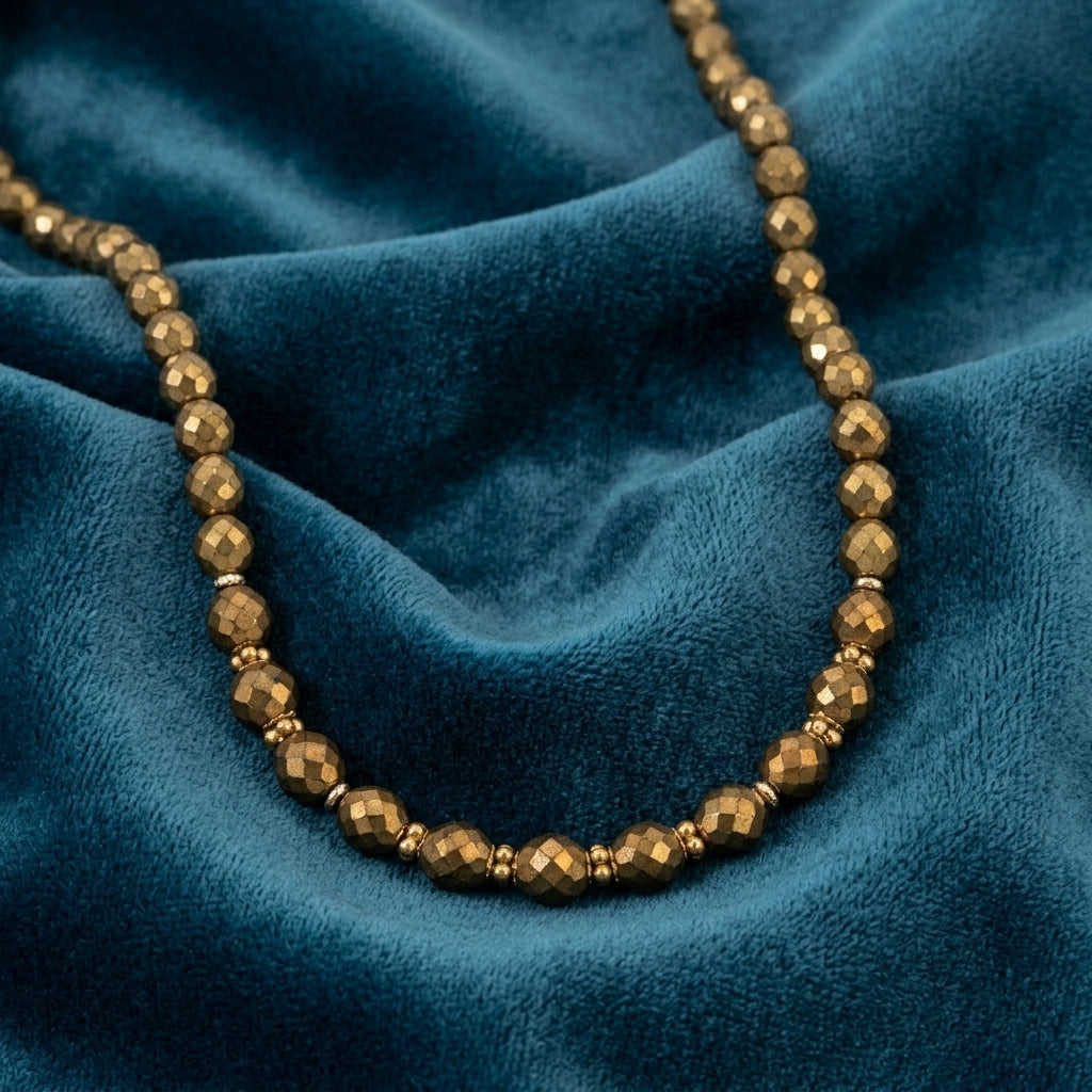 Bronze beaded necklace on a blue fabric background