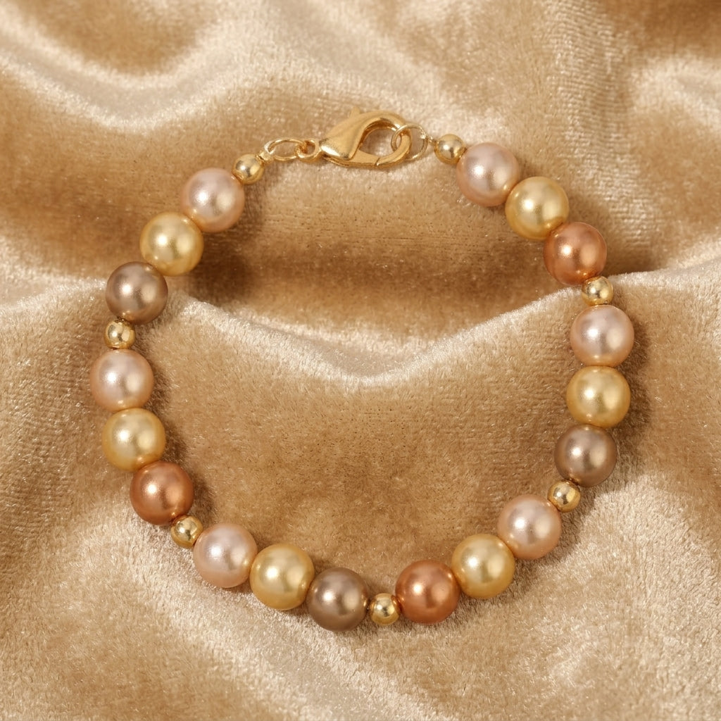 Pearl bracelet with gold accents on a beige satin background