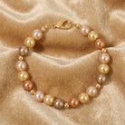 Pearl bracelet with gold accents on a beige satin background