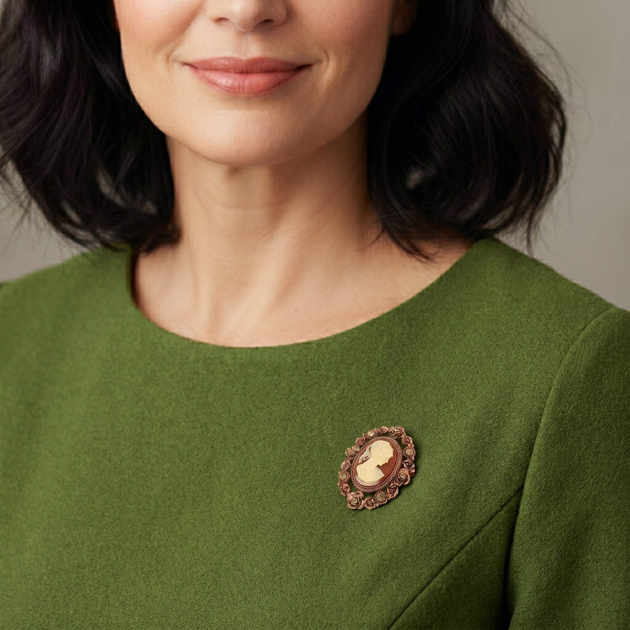 Woman in a green top wearing a Floral & Topaz Crystal Cameo Brooch