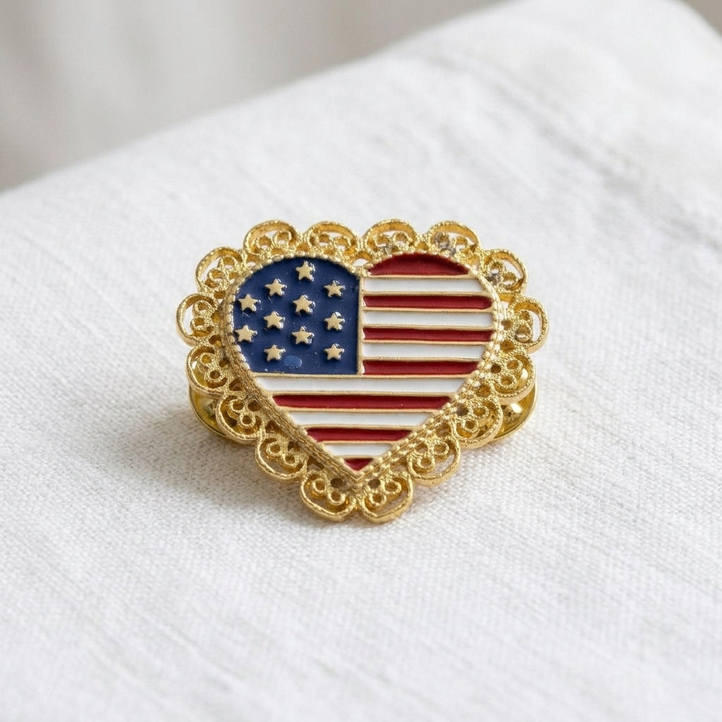Heart-shaped American flag pin with gold border on a white background