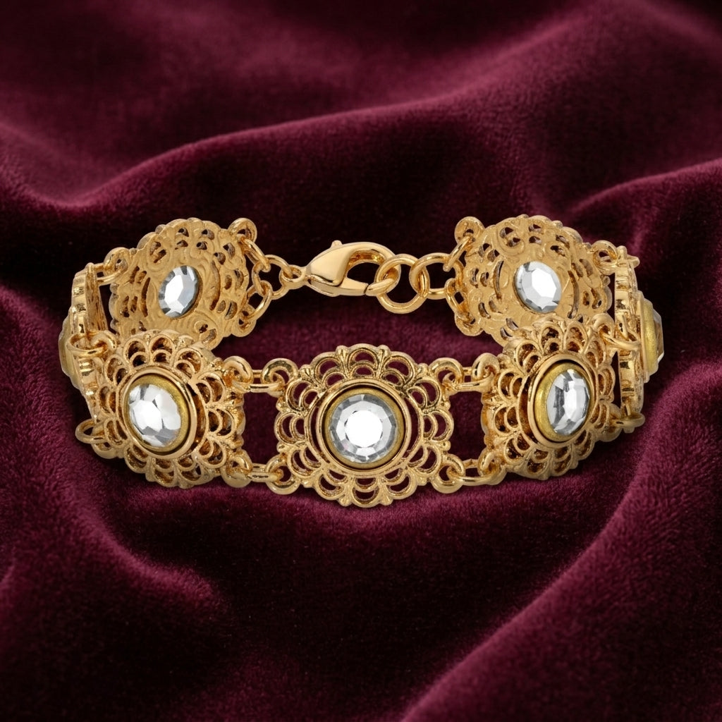 Gold bracelet with clear crystals on a burgundy fabric background