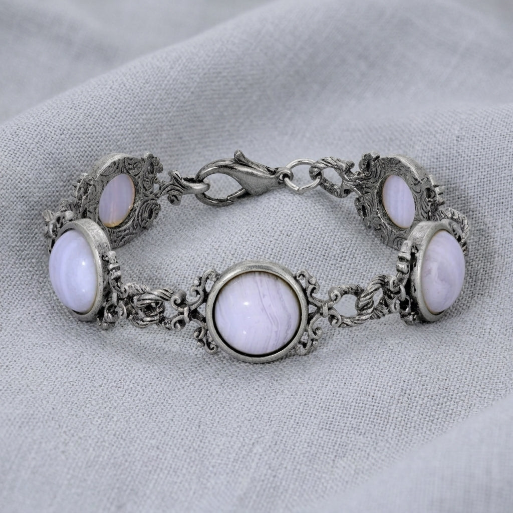 Silver bracelet with purple cabochon stones on a light fabric background
