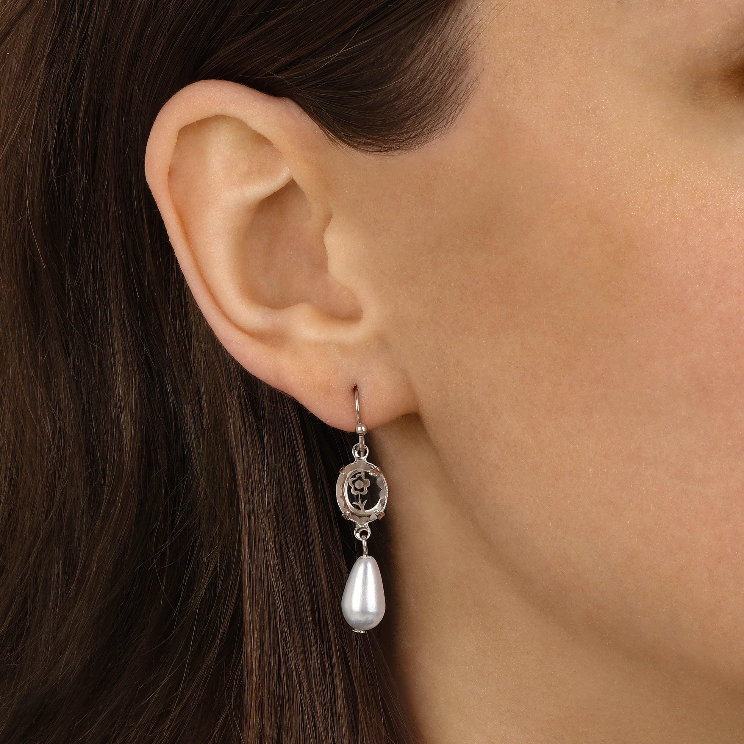 A close-up of a model's ear wearing Silver Tone Flower Glass Crystal & Faux Pearl Teardrop Dangle Earrings