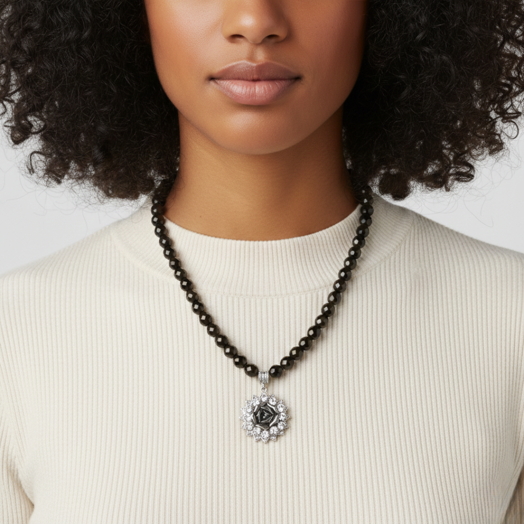 Woman wearing a necklace with a decorative pendant against a neutral background