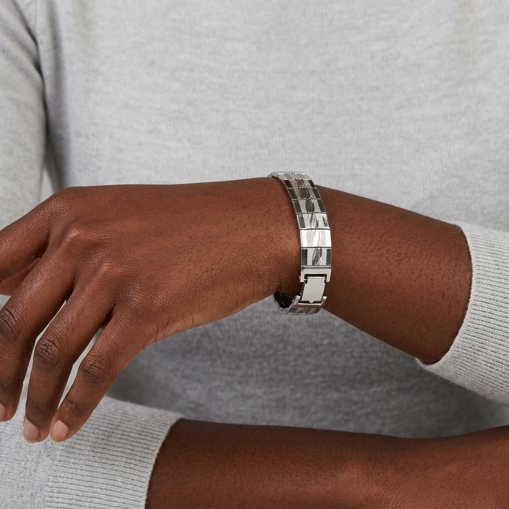 Person wearing a silver bracelet on a neutral background