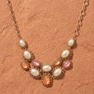 Golden Peppermint & Toffee Oval Stone Pearl Bib Necklace on a sandstone surface