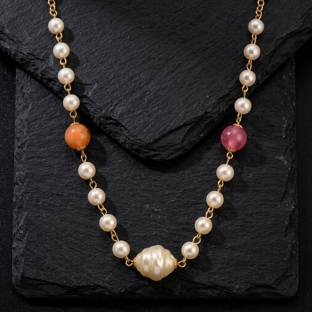 Pink & Peach Beaded Faux Pearl Necklace resting on a black stone surface