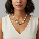 Woman wearing a pearl cameo necklace with a plain background