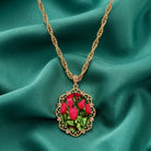 Gold tone necklace with a tulip design resting in teal fabric 