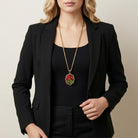 Woman in a black business outfit wearing a gold tone pendant necklace with tulip design