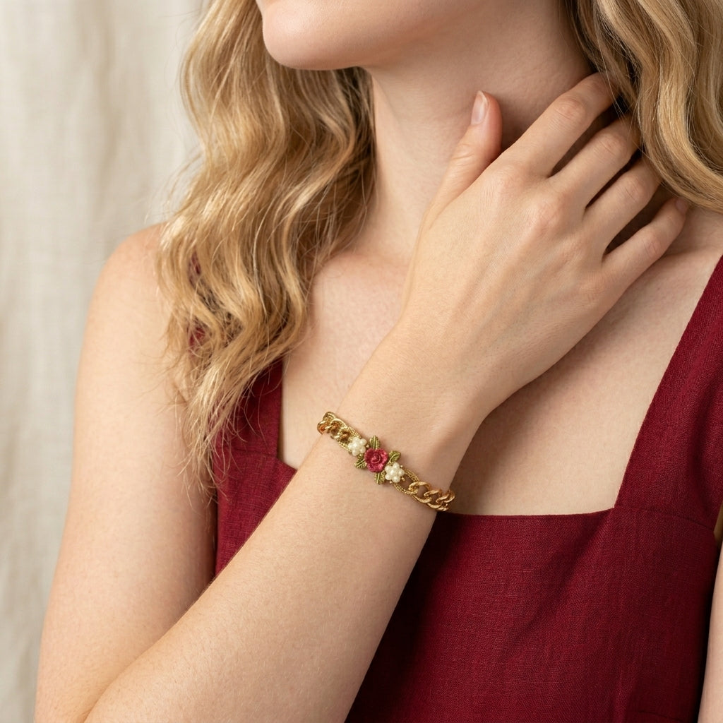Woman wearing a gold bracelet with red rose and white faux pearl beads designed like flowers
