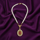 Pearl necklace with a decorative pendant on a purple fabric background