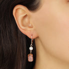 Close-up of an ear wearing our Golden Pearl & Peach Cracked Glass Bead Leverback Drop Dangle Earrings