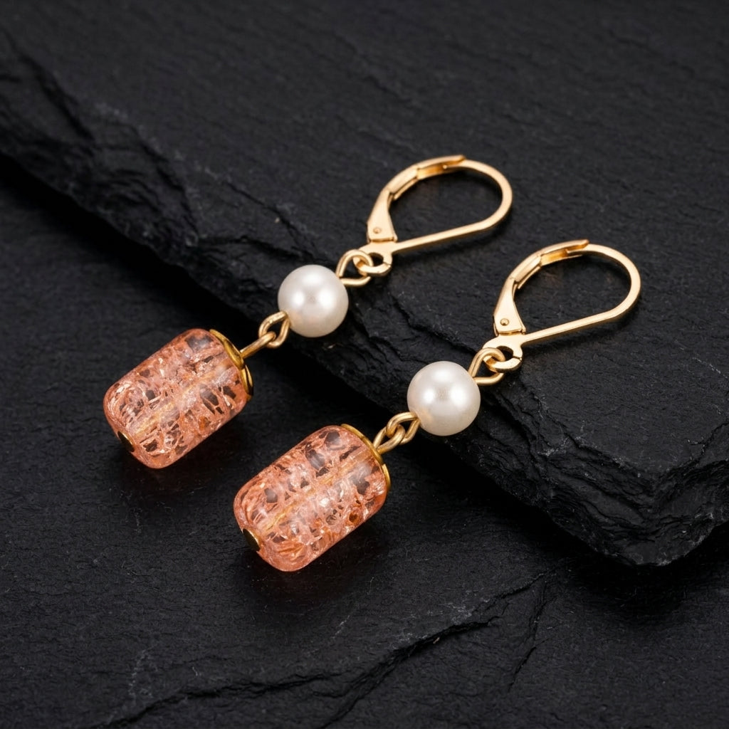 Peach and Faux Pearl leverback earrings resting on a dark stone surface