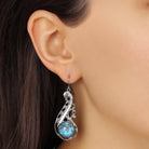 Close up of a woman wearing Swirly Statement Round Turquoise High Dome Stone Drop Earrings