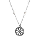 Silver necklace with a round floral pendant on a white background