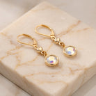 Golden Heart Channel AB Crystal Drop Earrings on champagne colored marble