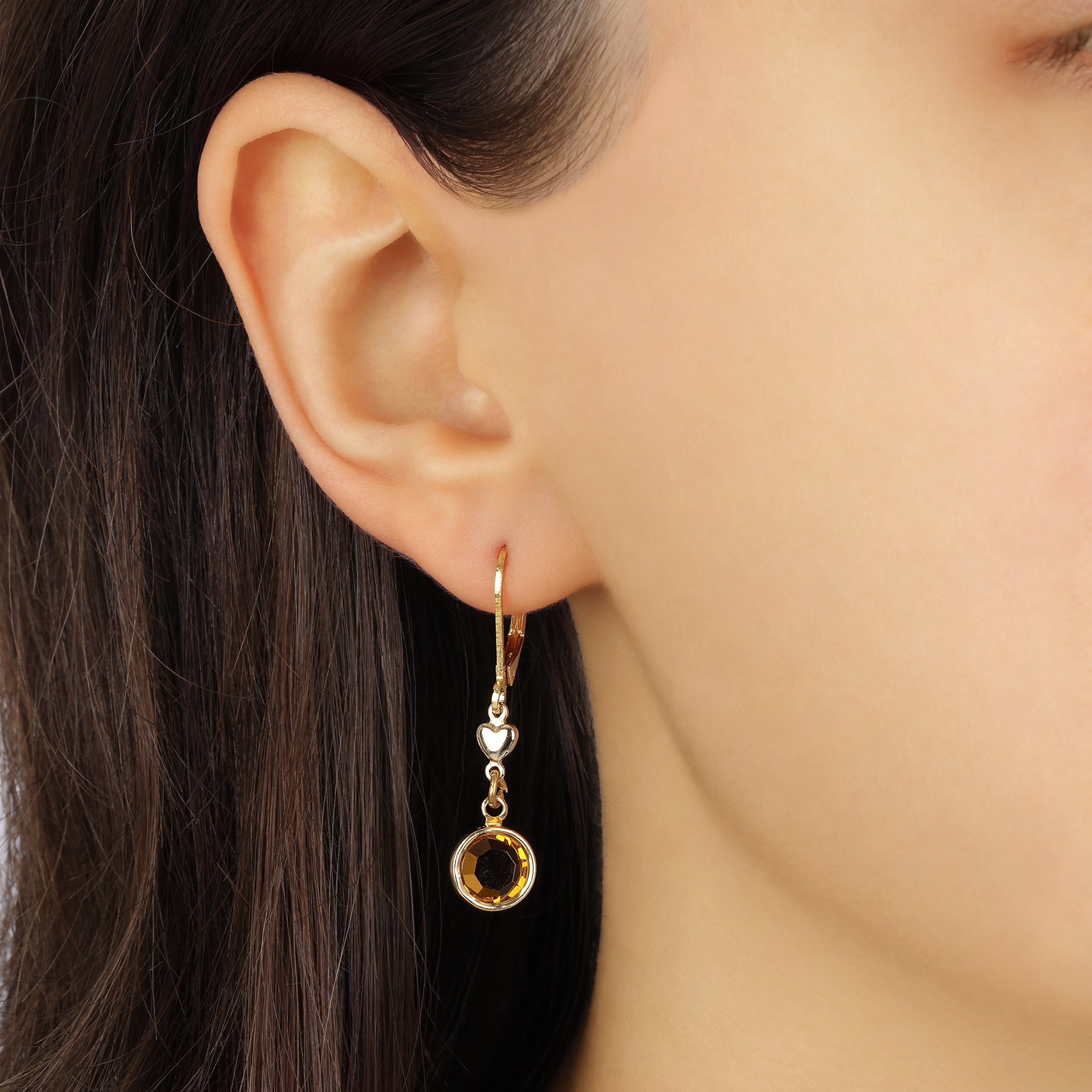 Close up of a woman wearing Golden Heart Channel Topaz Crystal Drop Earrings