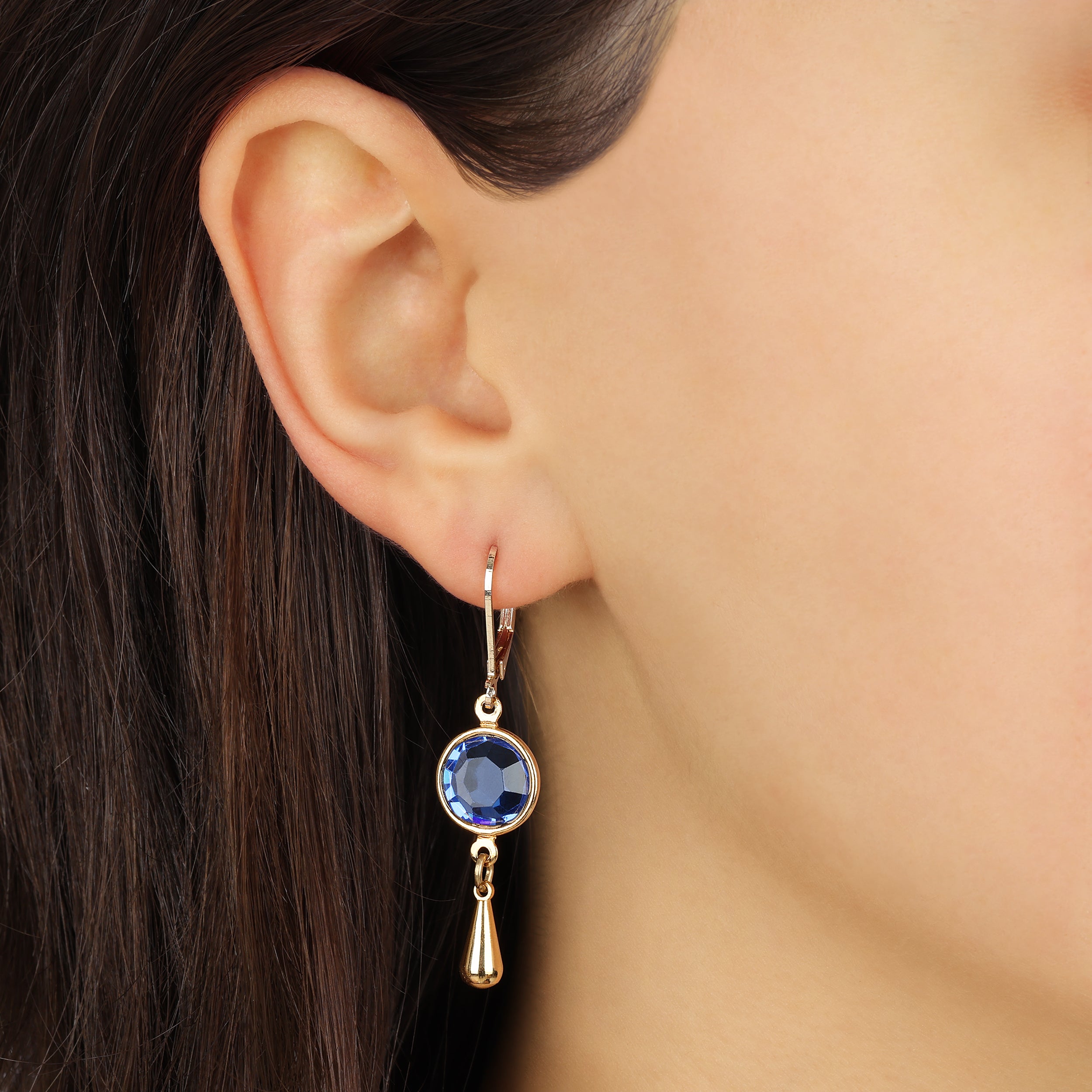 Close up of a woman wearing Golden Sapphire Blue Channel Crystal Pear Drop Earrings