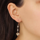Close up of a woman wearing Classic Golden Heart Drop & Dangle Earrings