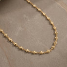 Classic Golden Heart Link Chain Necklace 16" displayed on a textured gray surface.