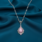 Necklace with a pink pendant on a blue fabric background