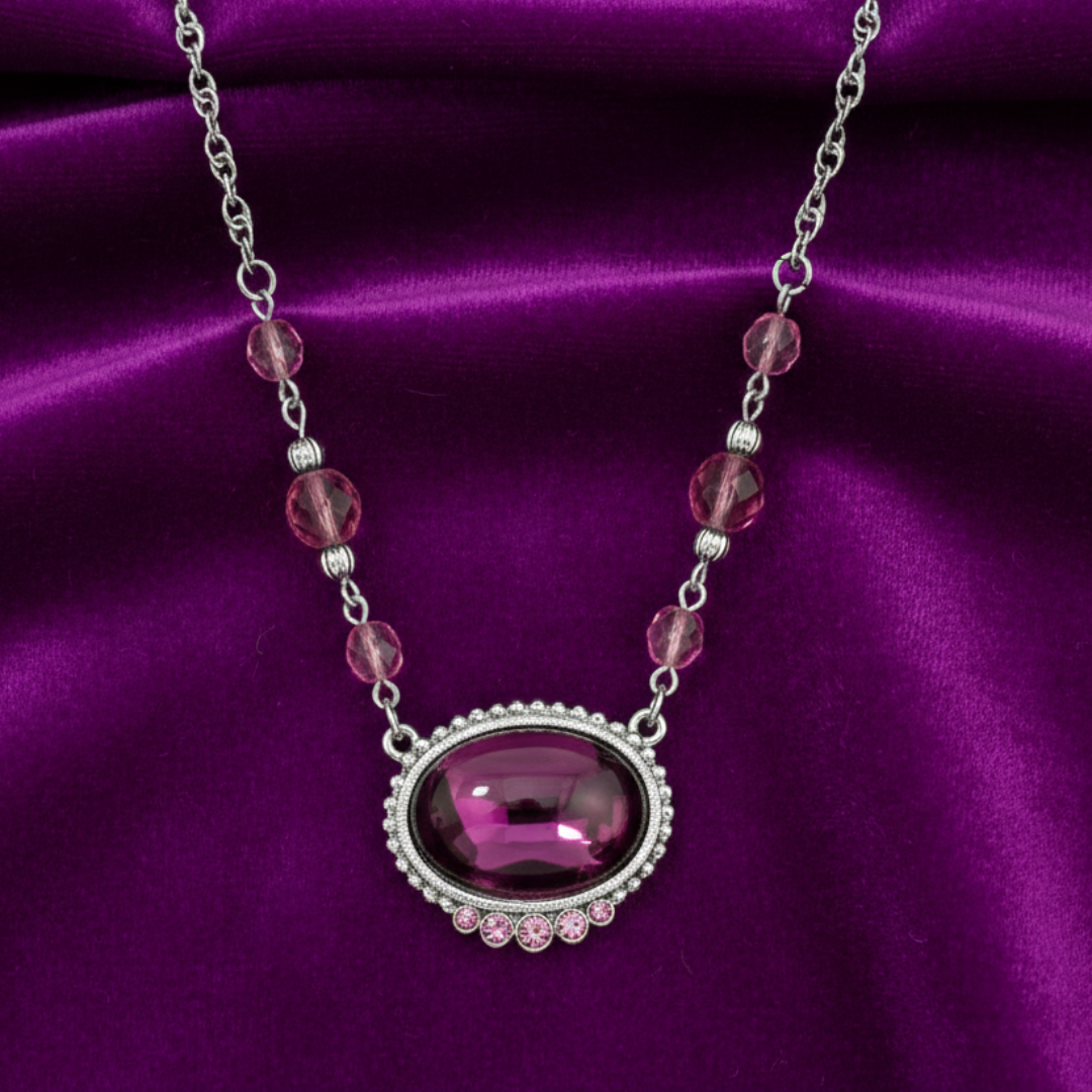 Necklace with a purple pendant on a purple satin background