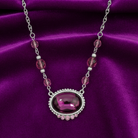 Necklace with a purple pendant on a purple satin background