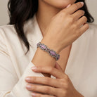 Woman wearing a bracelet with pink stones on a neutral background