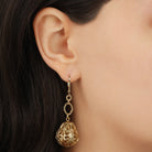 Close up of a woman wearing Golden Bell Shaped Filigree Drop & Dangle Earrings