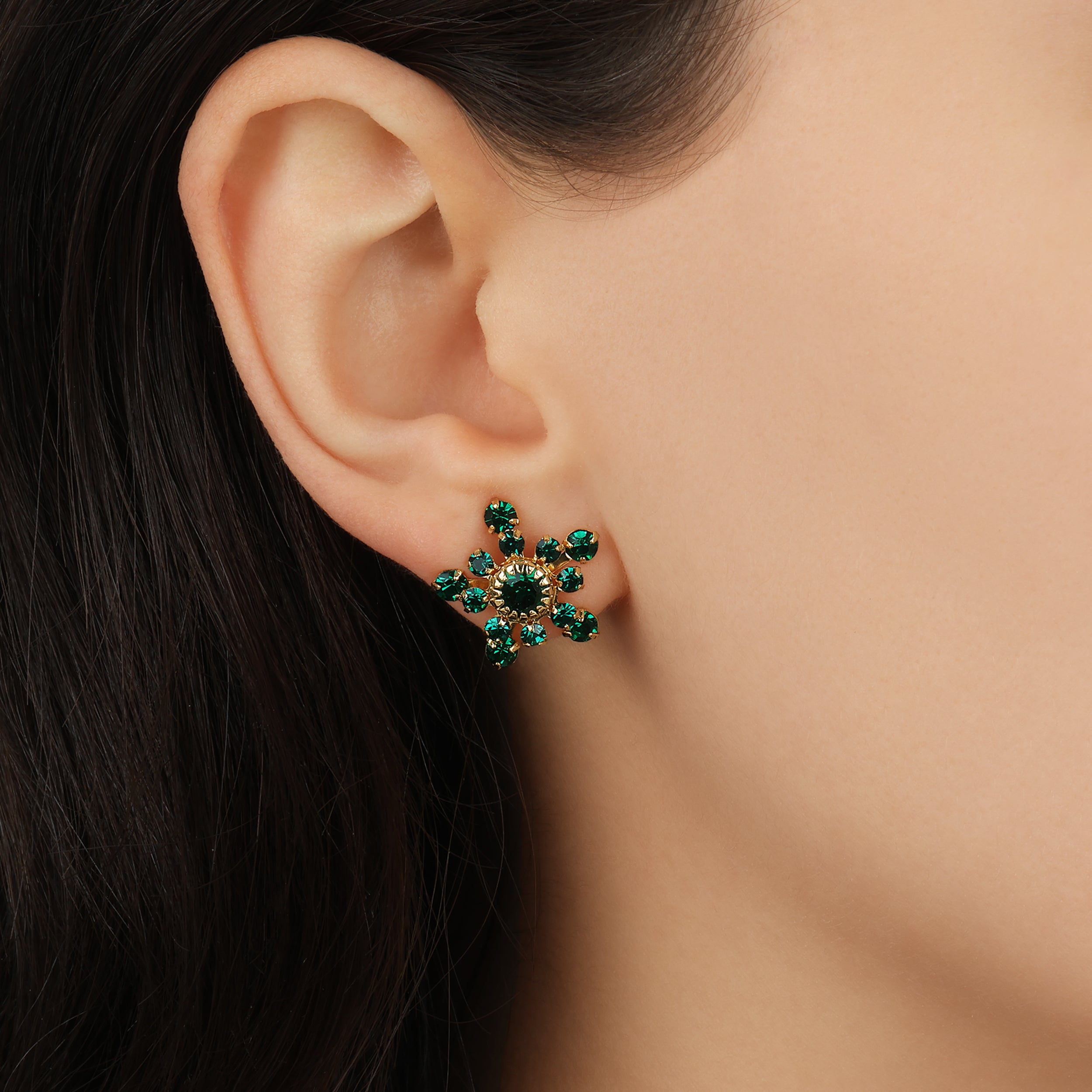 Close up of a female model wearing Emerald Green Crystal Gold Star Stud Earrings