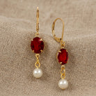 Oval Siam Red Crystal & Pearl Bead Drop & Dangle Earrings resting on beige linen